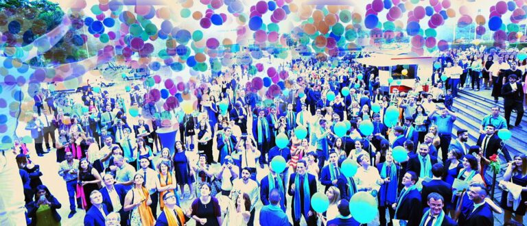 Menschenmenge bei einer Großveranstaltung mit bunten Ballons und Feierlaune.