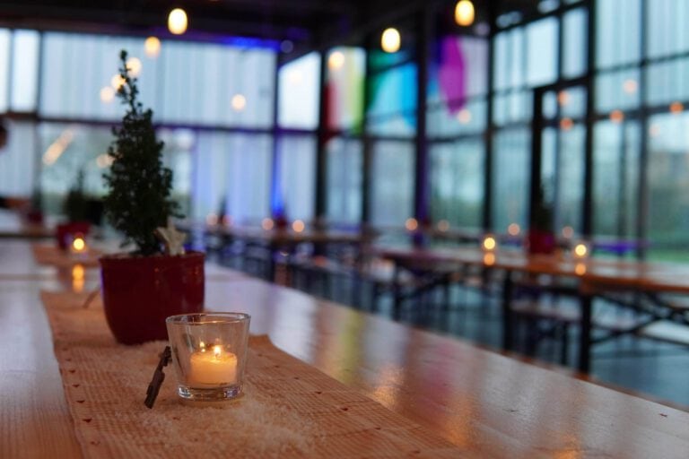 Gemütliche Weihnachtsfeier bei PURA Erlebnismanufaktur mit Kerzenlicht und festlicher Atmosphäre.
