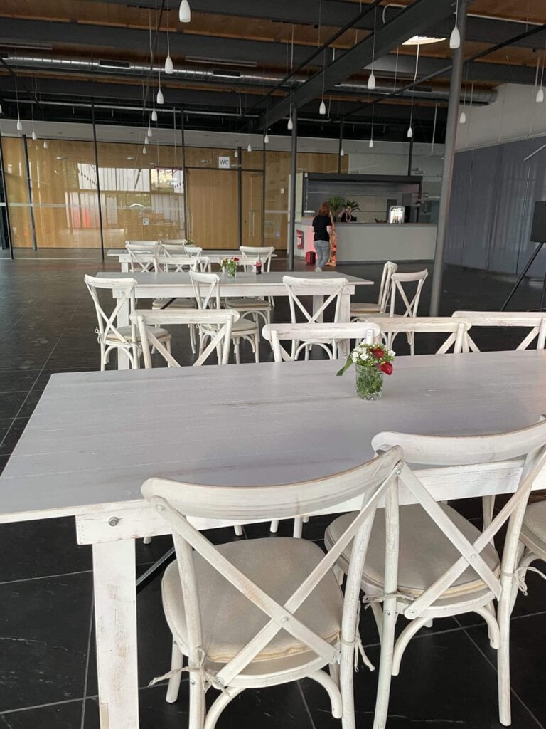 Moderne Eventlocation mit weißen Tischen und Stühlen bei Klaus Faber Sommerfest.