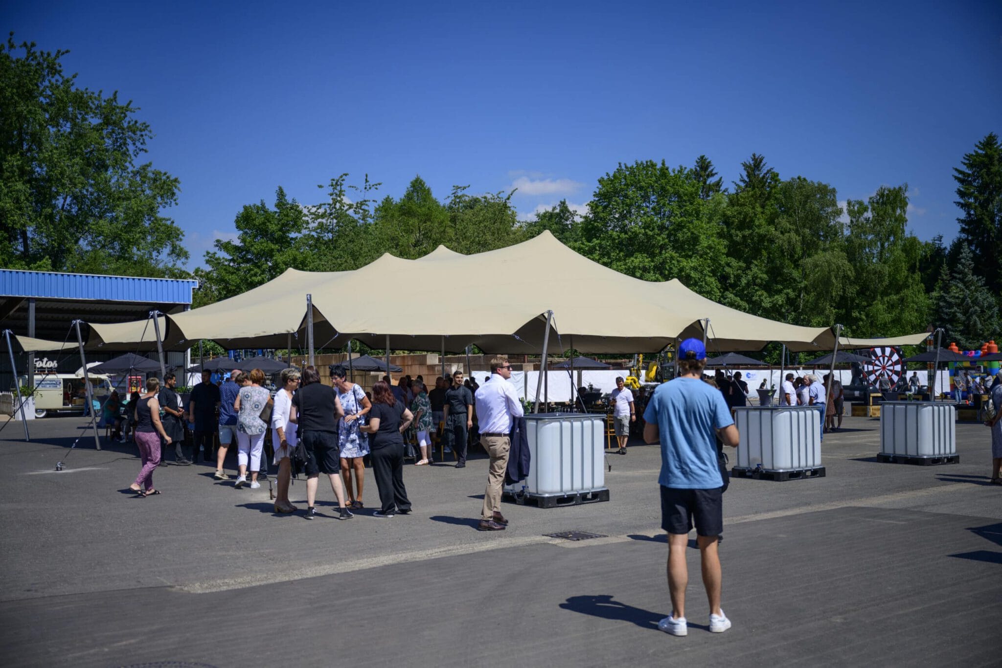 Sommerfest bei PURA Erlebnismanufaktur mit Menschen unter Zelt.