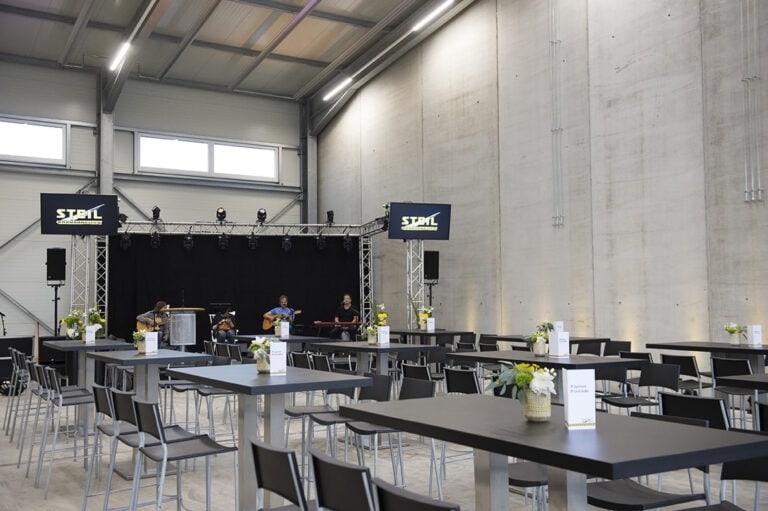 Event im PURA Erlebnismanufaktur mit Bühne und Sitzgelegenheiten.