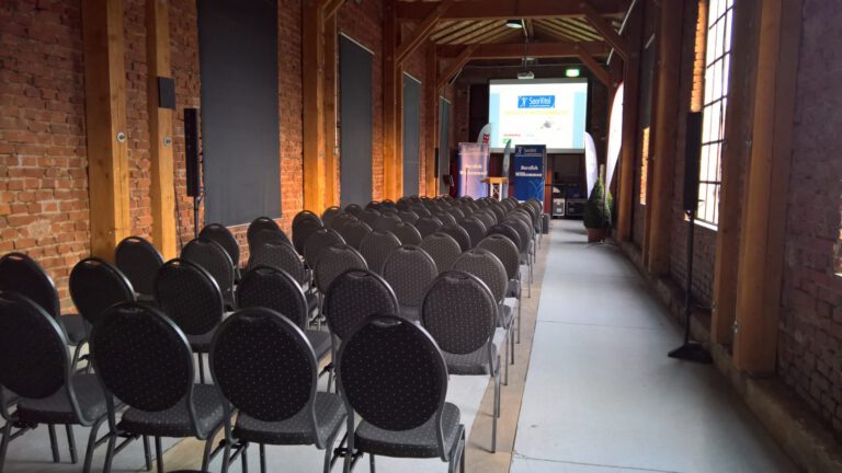 Stilvolle Veranstaltungsbestuhlung in einer Industriehalle für Messegestaltung.