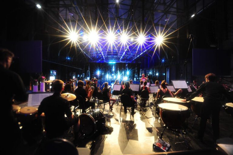 Musiker bei Grad Night in der PURA Erlebnismanufaktur mit Bühnenbeleuchtung.
