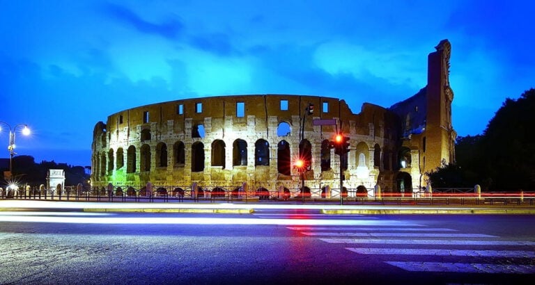 Historisches römisches Amphitheater bei Nacht, beleuchtet.