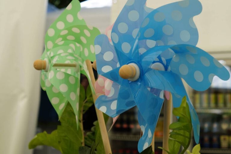 Bunte Windmühlen aus Kunststoff für Kinder, grün und blau mit Polka-Dots.