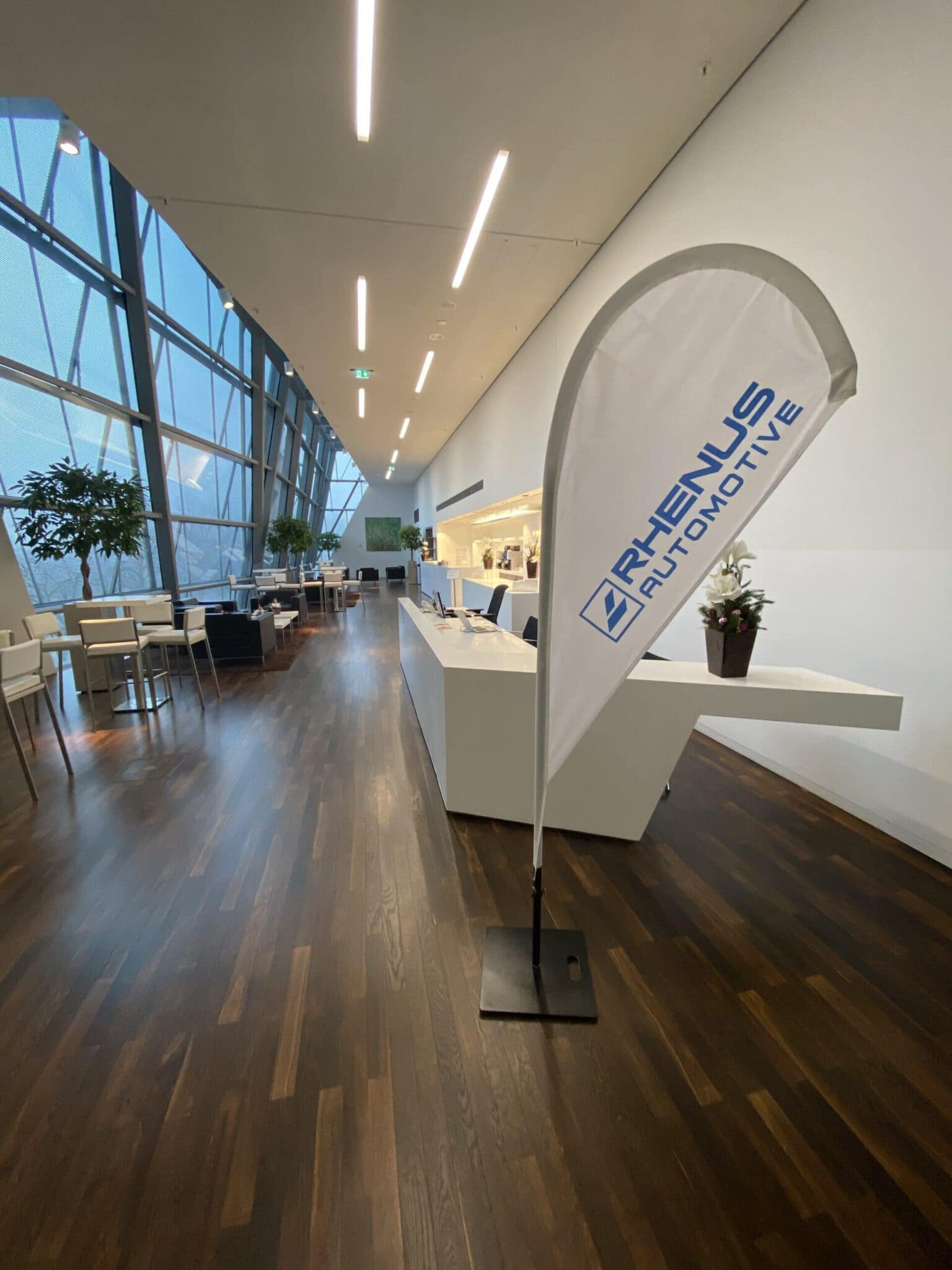 Moderne, helle Lobby mit großen Fenstern und Rhenus Automotive Banner.