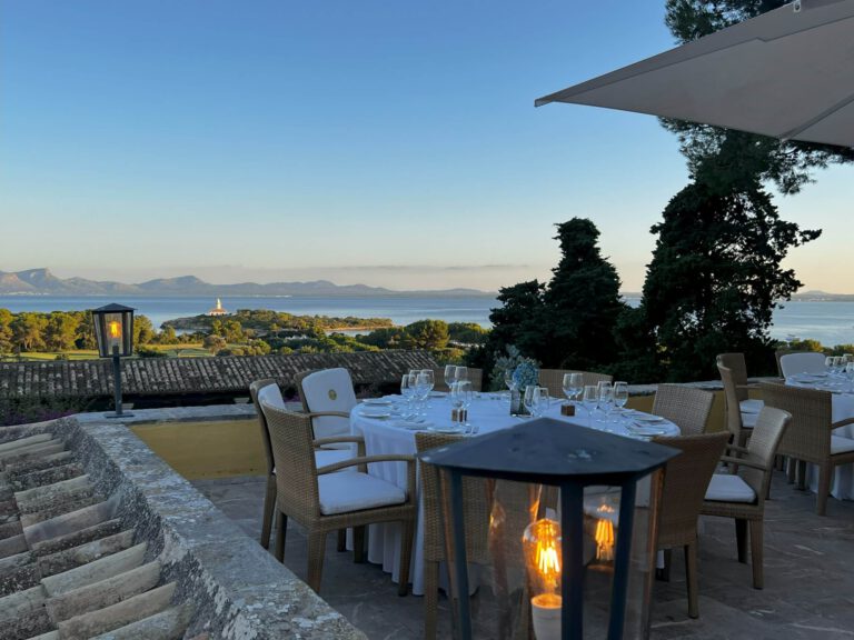 Elegantes Restaurant mit Blick auf den See und Berge bei Sonnenuntergang.
