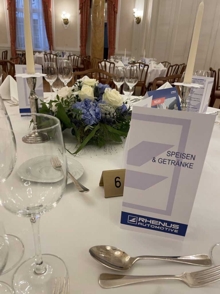 Eleganter gedeckter Tisch bei PURA Erlebnismanufaktur mit Blumen und Kerzen.